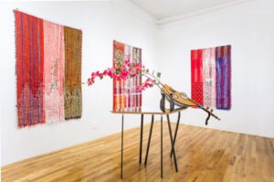 Colorful woven textiles and sculpture with flowers