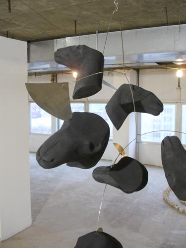 Hanging black sculpted horse heads installation