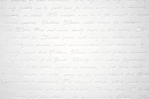 Embossed white cursive handwriting on paper