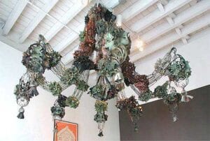 A chandelier with green and brown leaves hanging from the ceiling.